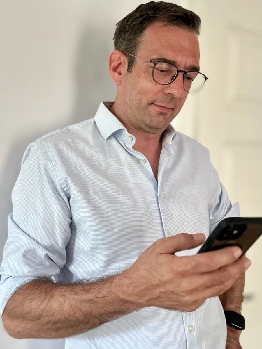 Thomas Kohns liest etwas auf seinem Telefon